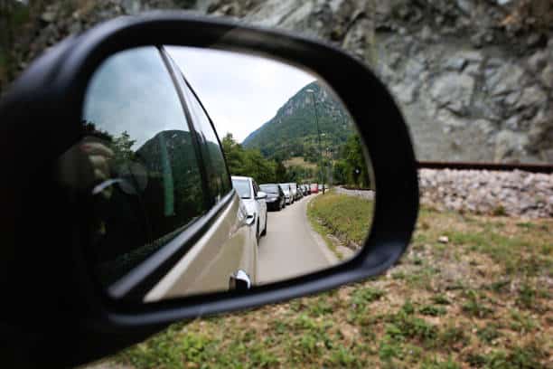 Gros plan sur un rétroviseur où l'on peut voir un embouteillage de voitures