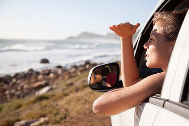 Femme dans une voiture qui regarde le paysage par la fenêtre
