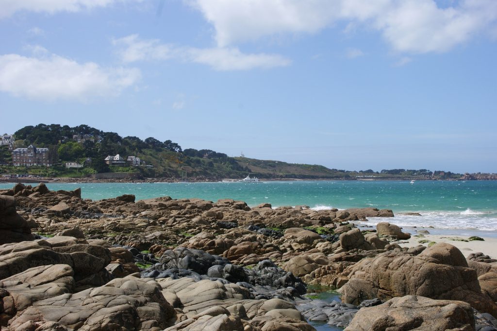 Vue de la mer depuis une plage bordée par des rochers à Perros-Guirec